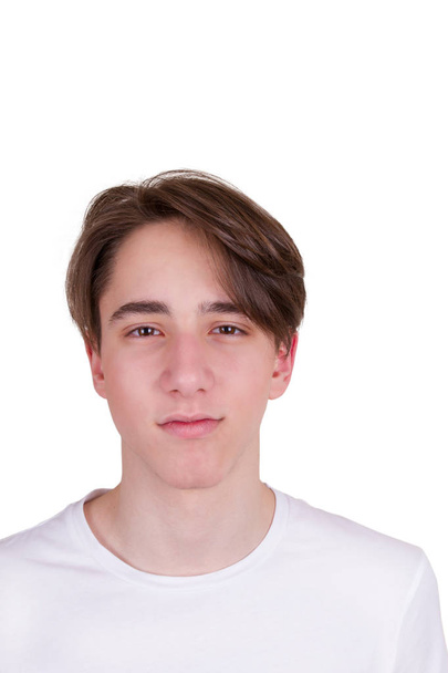 Handsome teen boy  looking at camera. Portrait of young man in white T-shirt, isolated on white background - Zdjęcie, obraz