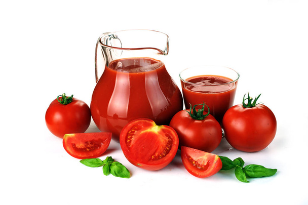 Jug, glass of tomato juice and fruits with green leaves  - Foto, Bild