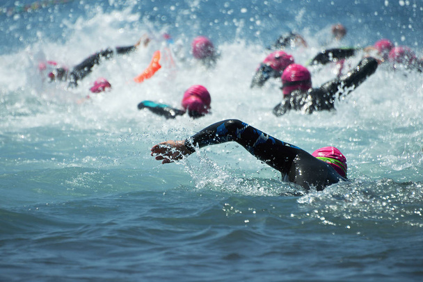 Ryhmä ihmisiä märkäpuku uinti triathlon
 - Valokuva, kuva