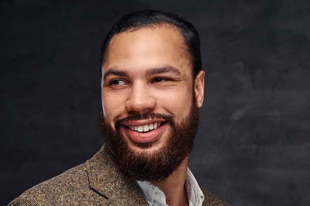 Макро портрет посміхаючись красивий бородатий афро-американський бізнесмен в коричневих класичний піджак. Ізольовані на темному тлі.  - Фото, зображення