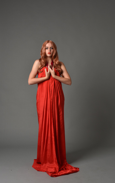 retrato de longitud completa de la mujer con un vestido de seda rojo, de pie pose sobre fondo gris estudio
. - Foto, imagen