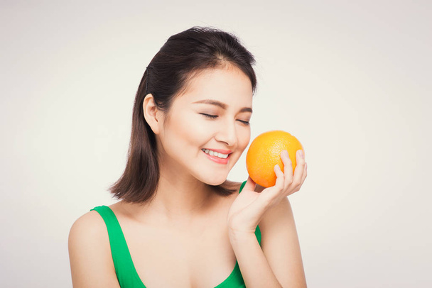 Beautiful asian portrait of young woman with oranges. Healthy food concept. Skin care and beauty. Vitamins and minerals. - Zdjęcie, obraz