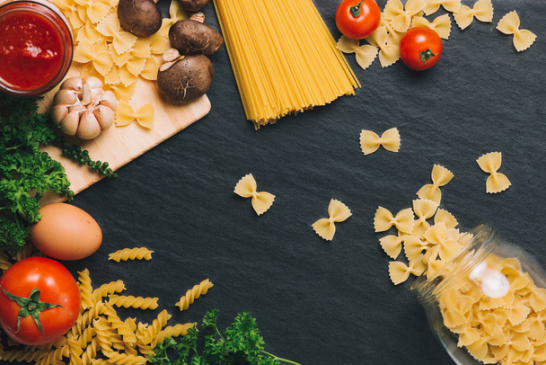 Итальянская кухня. Ингредиенты пасты. Вишневые помидоры, спагетти, розмарин и специи
 - Фото, изображение