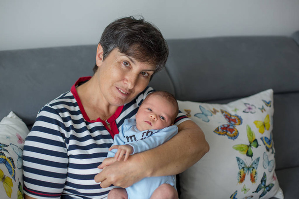 Beautiful baby boy in grandmothers arms - Valokuva, kuva