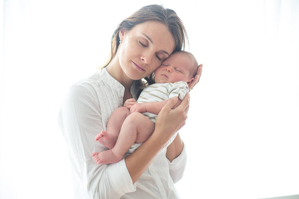 Young mother, holding her newborn baby boy - Zdjęcie, obraz
