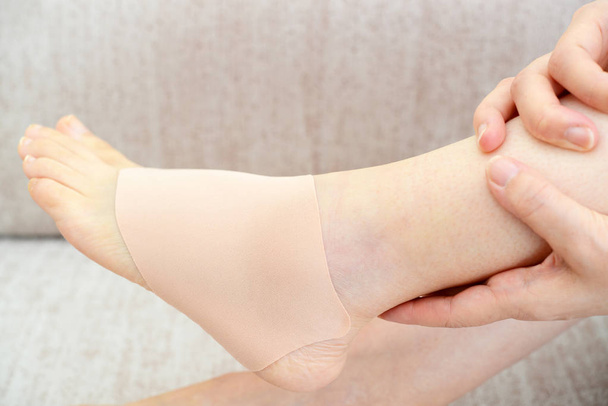 Mujer sosteniendo doloroso esguince de tobillo
 - Foto, Imagen