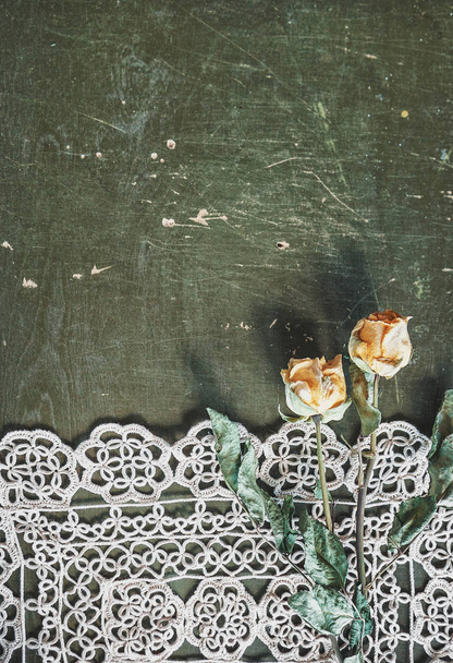 Εκλεκτής ποιότητας φόντο με τραπεζομάντηλο δαντέλα και τα ξηρά τριαντάφυλλα σε παλιό woo - Φωτογραφία, εικόνα
