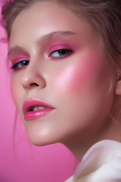 young girl with pink make-up. beauty close-up on pink background. messy hair with white flowers. healthy glowing skin - Foto, Bild