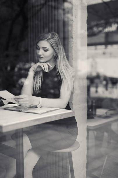 Beautiful girl sitting on the table and do her work, talk at pho - Fotoğraf, Görsel