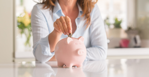 Middle age woman with piggy bank coin, saving and money concept, - Fotó, kép