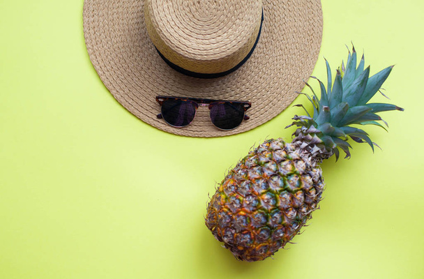 Accessoires de plage d'été. Chapeau de paille, lunettes de soleil, ananas. L'été. Brillant. Fond jaune. Chaud
. - Photo, image