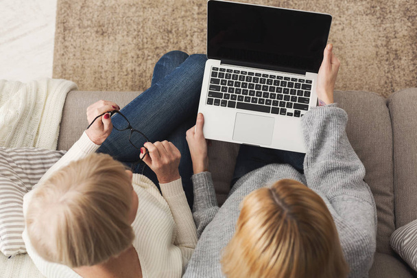 Доросла жінка і дочка використовують вид зверху на ноутбук
 - Фото, зображення