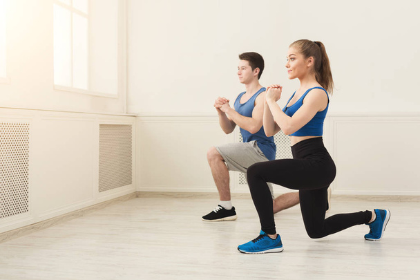 Jeune couple en vêtements de sport faire squat
 - Photo, image