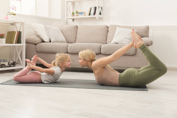 Mutter und kleine Tochter machen gemeinsam Yoga - Foto, Bild