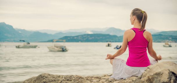 Woman meditating at the lake - Photo, Image