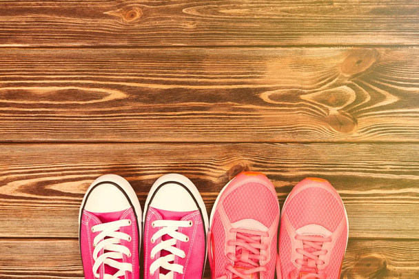 Pink sneakers on wooden texture - Photo, Image