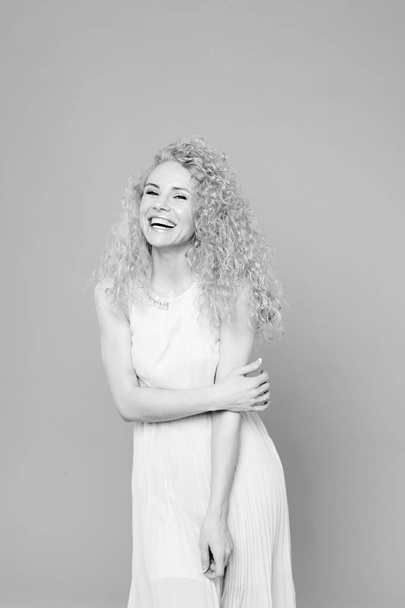 Portrait of a pretty curly blonde woman, wearing light dress - Foto, Imagem