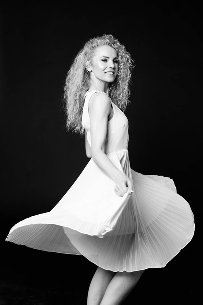 Portrait of a pretty curly blonde woman, wearing light dress - Foto, afbeelding