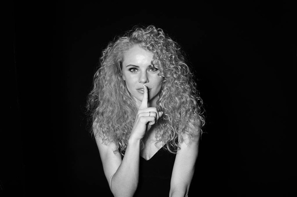 Portrait of a pretty curly blonde woman, wearing black dress - Photo, Image