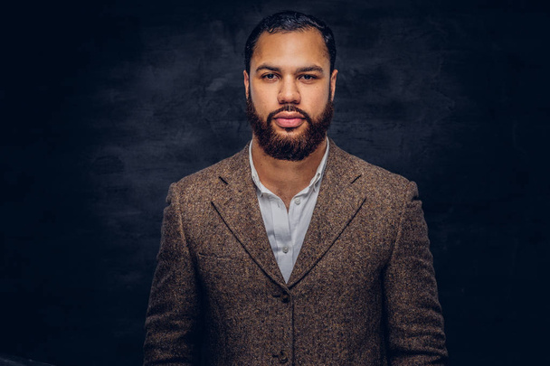 Handsome bearded African-American businessman in a brown classic jacket. Isolated on a dark background. - Photo, Image