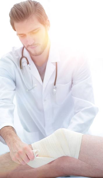 médico mirando el vendaje en la pierna de los pacientes
 - Foto, imagen