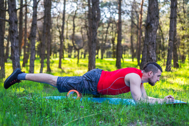 Man trainer showing exercises on the foam roller, the free space. - Photo, Image