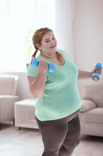 Plump red-head woman performing her everyday exercises - Photo, Image