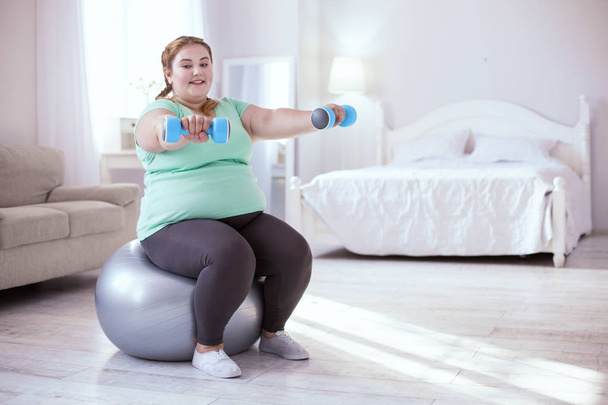 Stout young woman exercising to keep fit - Valokuva, kuva