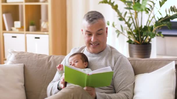 father reading book for little baby boy at home - Filmmaterial, Video