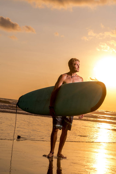 Surfer with surfboard on the beach - Zdjęcie, obraz