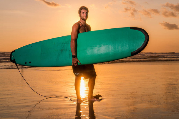 Surfer with surfboard on the beach - Foto, imagen