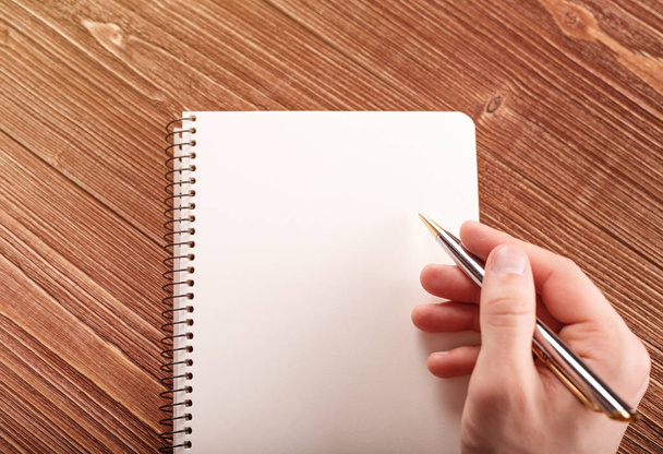 Рука людини з ручкою готується писати на блокноті
. - Фото, зображення