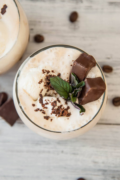 Iced Mocha Coffee with Whip Cream, Summer Drinking times. Coffee Beans. rustic textured Wooden Background. Mint Leaves - Zdjęcie, obraz