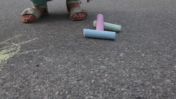 Criança menina desenha com giz colorido no pavimento de asfalto fechar ao ar livre
 - Filmagem, Vídeo