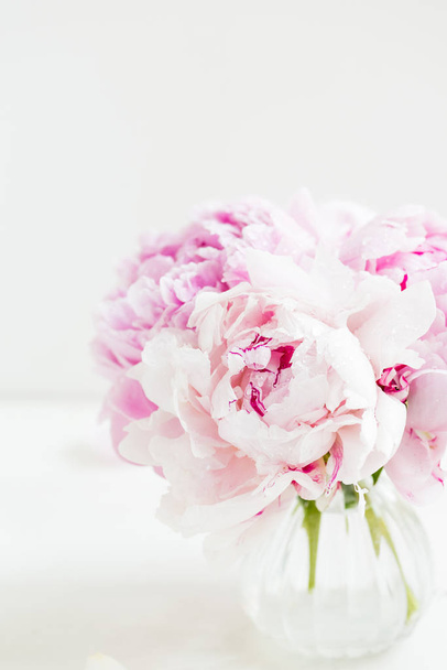 Fresh bunch of pink peonies in little vase on light background. Card Concept, copy space for text - Foto, Bild