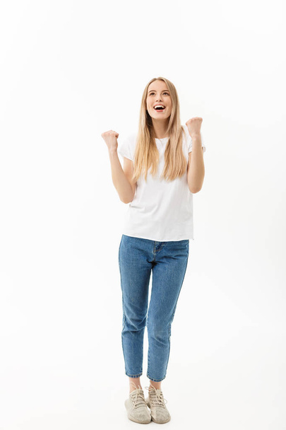 Full-length Portrait of a cheerful woman in white shirt and jean celebrating her success over white background - Fotografie, Obrázek