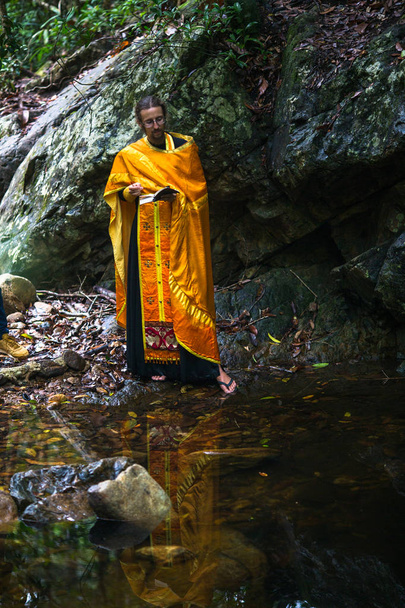 KOH CHANG, THAILAND - MAR 9, 2018: Orthodox priest during sacrament of spiritual birth - Baptism. There are currently 10 Orthodox parishes in Thailand, Orthodoxy is practiced by 0.002% of population. - Photo, Image