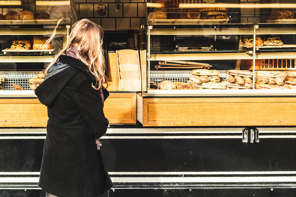 Κορίτσι μπροστά από ένα γαλλικό αρτοποιείο στο Παρίσι, Γαλλία - Φωτογραφία, εικόνα