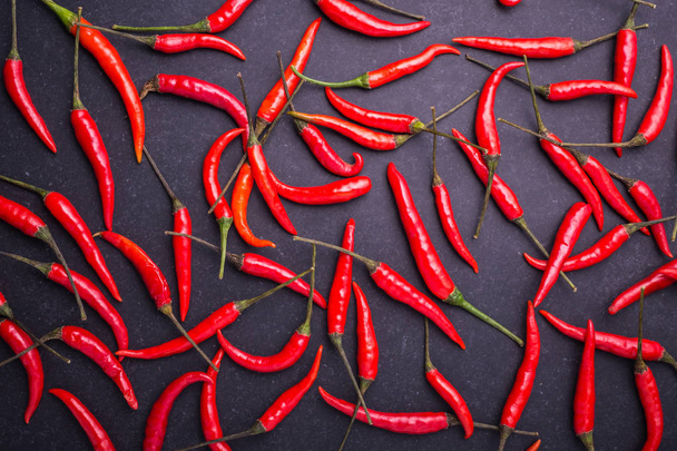 Top view fresh red hot chilli on black stone board  - 写真・画像