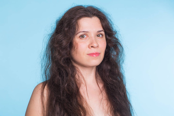 Portrait de femme nue sensuelle aux cheveux bouclés sur fond bleu
 - Photo, image