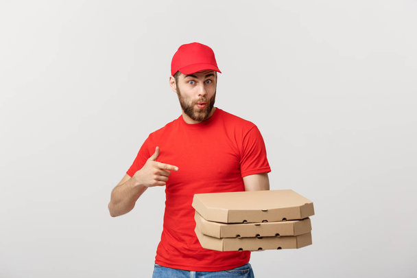 Conceito de entrega: Bonito caucasiano Entrega de pizza homem apontando dedo. Isolado sobre fundo cinza
. - Foto, Imagem