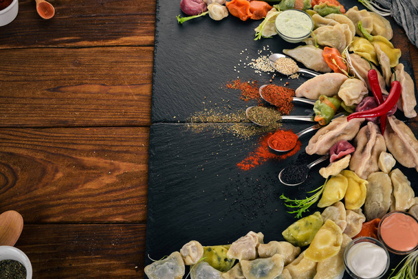 A great selection of dumplings. Ukrainian Traditional Cuisine. On a wooden background. Top view. Copy space. - 写真・画像