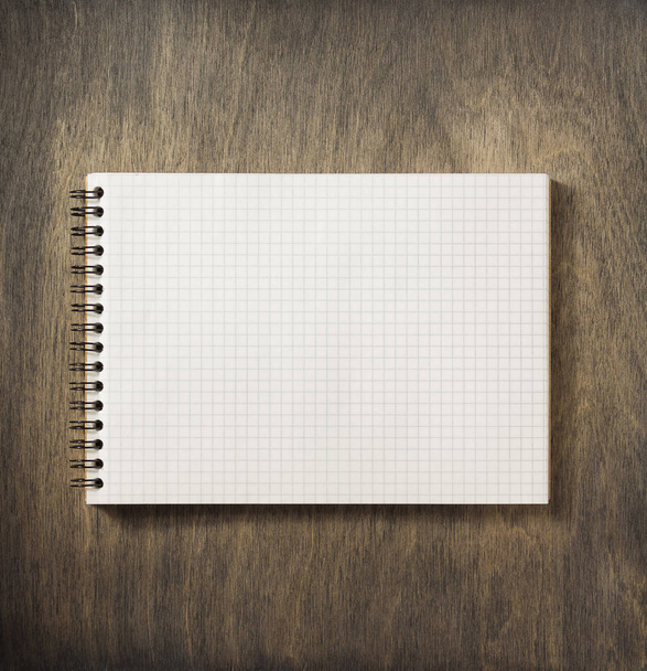 checked notebook at wood - Фото, изображение