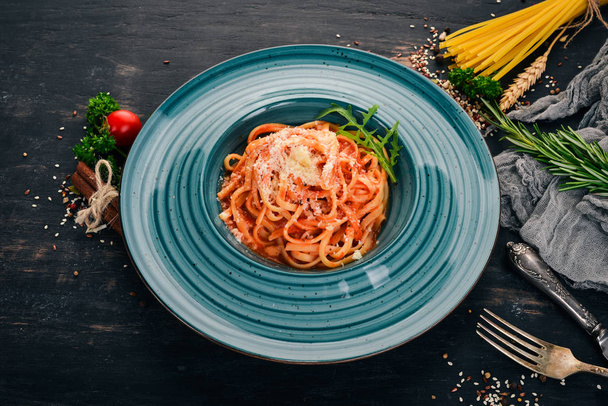 Linguine Pasta with tomatoes. On a wooden background. Italian cuisine. Top view. Copy space. - Zdjęcie, obraz