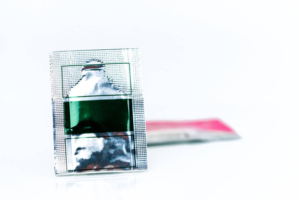 Mild steroid oral paste in aluminium foil sachet on blur background of sachets. Anti-inflammatory for oral mucous membrane, relief oral tenderness, pain, and ulceration. Aphthous ulcer or mouth ulcers - 写真・画像