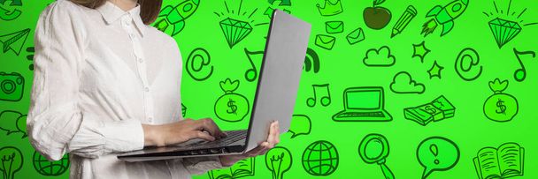 Το κορίτσι με το laptop στα χέρια σε πράσινο φόντο με εικονίδια - Φωτογραφία, εικόνα