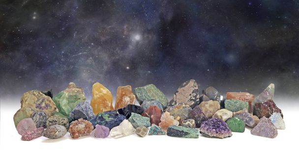 Kosmische Kristalle Sammlung - dunkler, tiefer Weltraum Hintergrund mit einer übersichtlichen Sammlung von 40 verschiedenen natürlichen rauen Gesteins- und Edelsteinpräparaten  - Foto, Bild