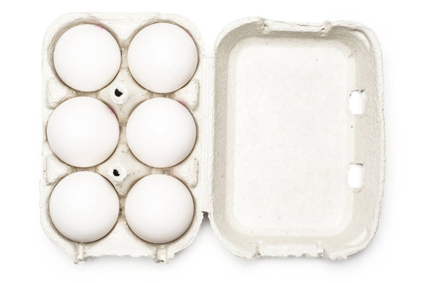 sechs weiße Hühnereier in einer papiergrauen Kiste isoliert auf weißem Hintergrund oben wetteifern - Foto, Bild