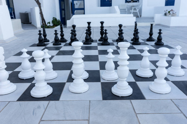 Grandes peças de xadrez no terraço ao ar livre. Jogo de xadrez ao ar livre
 - Foto, Imagem