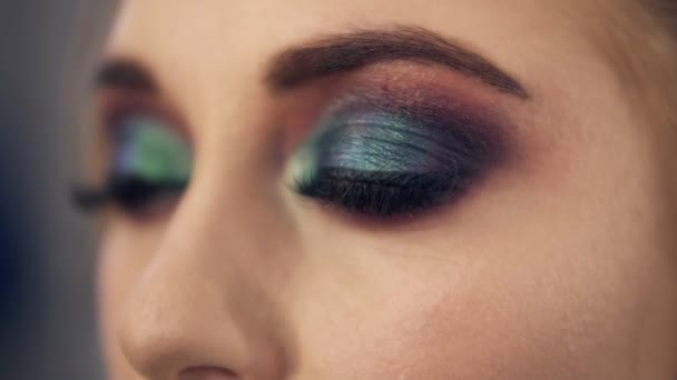 Seductive young woman with green eyes. Slowly open her eyes. Professional smoky eyes makeup. Close up - Video, Çekim